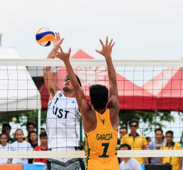Beach volleyball action shot of two players competing at a tournament in Pasay, Philippines.